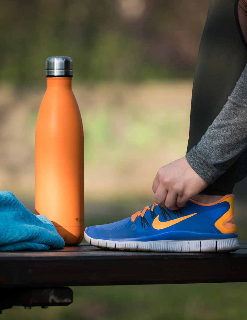 person tying show next to water bottle natural medicine