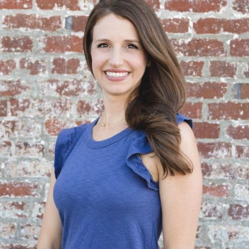 employee standing with a brick wall backdrop